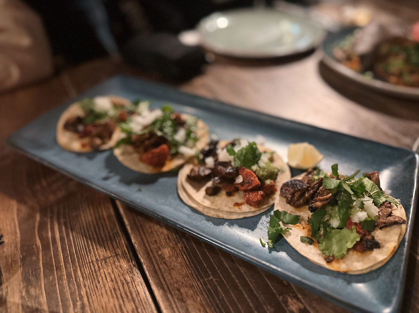 Mexikanisches Streetfood, man sieht vier Tacos mit Füllung