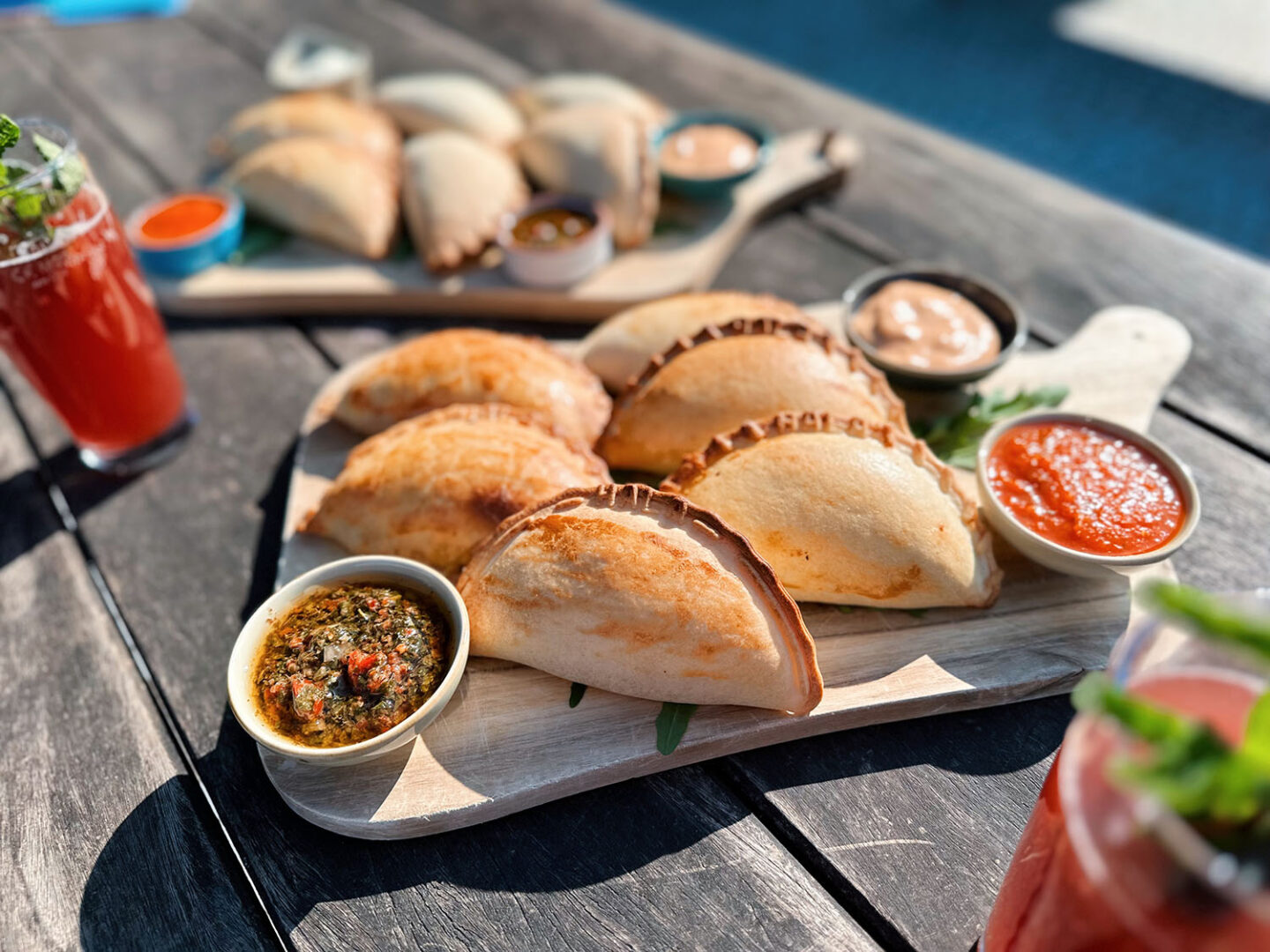 Empanadas, südamerikanische Teigtaschen, angerichtet mit Dips.