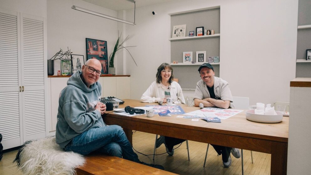Man sieht Mike Litt, links vorne, den Podcast-Host und gegenüber Lilly (links) und Alex an einem Tisch sitzend.