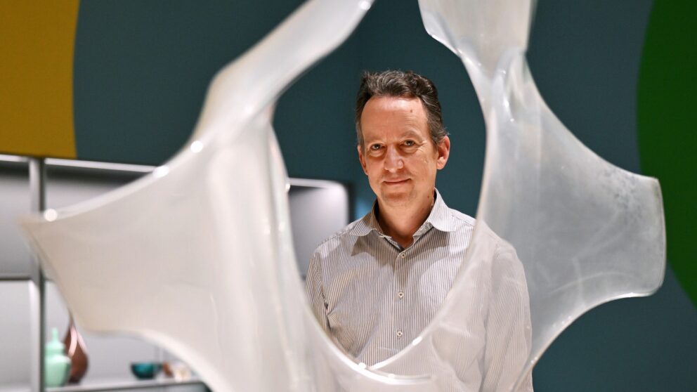 The director of the Kunstpalast glass collection can be seen peering out from behind glass sculptures in the Mythos Murano exhibition.